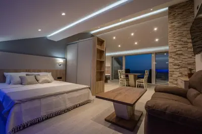 a bedroom with a bed and a table and a couch at SYMPHONY in Petrovac na Moru