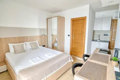 a bedroom with a bed and a desk with a computer at SYMPHONY in Petrovac na Moru