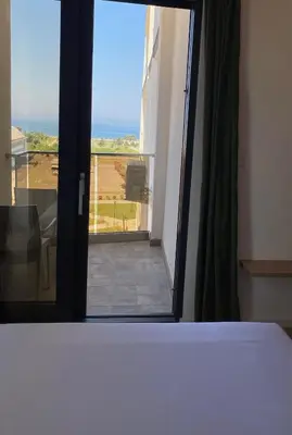 a room with a window with a view of a balcony at EmZa Sea View Apartment in Bar