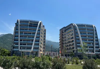 two tall buildings with mountains in the background at EmZa Sea View Apartment in Bar