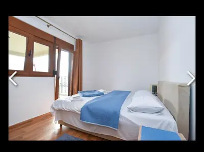 a bedroom with a bed with blue sheets and a window at Apartments Teona in Bar