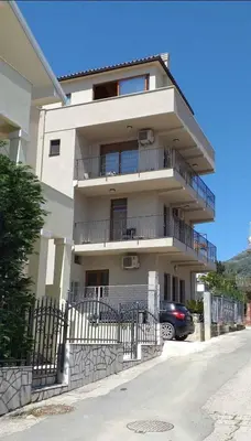 a large white building with a car parked in front of it at Apartments Teona in Bar