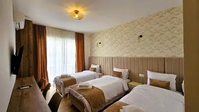 a hotel room with three beds and a window at Villa Alba Apartments in Dobra Voda