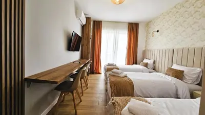a hotel room with two beds and a desk at Villa Alba Apartments in Dobra Voda