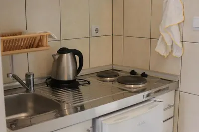 a kitchen with a stove with a tea kettle on it at Villa Alba Apartments in Dobra Voda