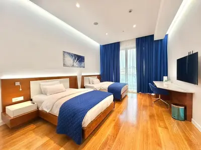 a hotel room with two beds and a desk at Condo Studio Plaza in Budva