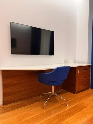 a desk with a tv and a blue chair at Condo Studio Plaza in Budva