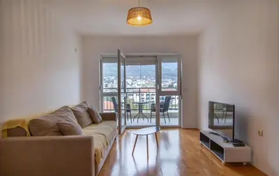 a living room with a couch and a television at Apartment Plamenatz in Bar