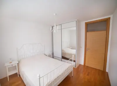 a white bedroom with a bed and a mirror at Apartment Plamenatz in Bar