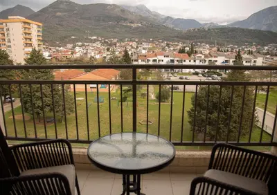 a table and chairs on a balcony with a view of a city at Apartment Plamenatz in Bar