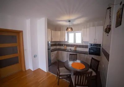 a small kitchen with a table and chairs in it at Apartment Plamenatz in Bar