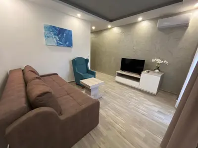 a living room with a brown couch and a television at Heaven Lux Ulcinj in Ulcinj