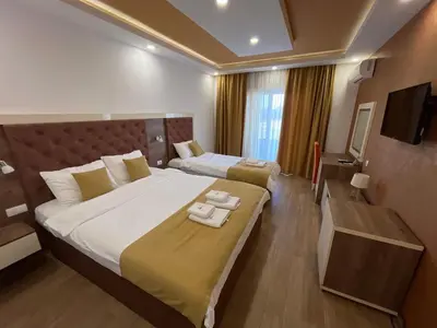 a hotel room with a large bed and a television at Heaven Lux Ulcinj in Ulcinj