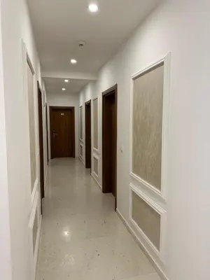 a hallway with white walls and brown doors at Heaven Lux Ulcinj in Ulcinj