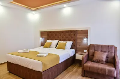 a bedroom with a large bed and a chair at Heaven Lux Ulcinj in Ulcinj