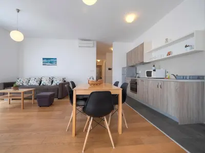 a kitchen and living room with a table and chairs at Seaside Rest Apartments in Budva