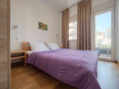 a bedroom with a purple bed and a window at Seaside Rest Apartments in Budva