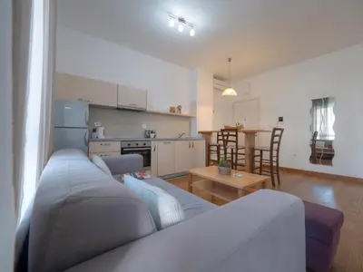 a living room with a couch and a kitchen at Seaside Rest Apartments in Budva