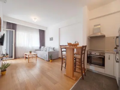 a kitchen and living room with a table and a couch at Seaside Rest Apartments in Budva