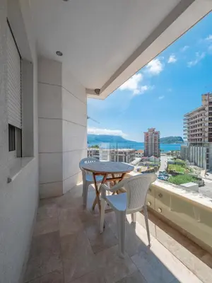 a balcony with a table and chairs and a large window at Seaside Rest Apartments in Budva