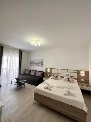 a bedroom with a large bed and a couch at Apartmens Xhenis Lux in Ulcinj