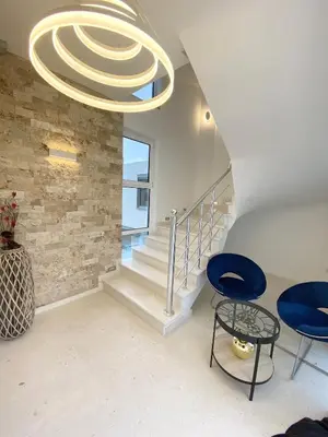 a room with a staircase and a chandelier at Apartmens Xhenis Lux in Ulcinj