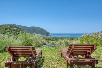 two wooden benches sitting in the grass near the ocean at Two Bedroom House with Sea View MAJ in Ðurovići
