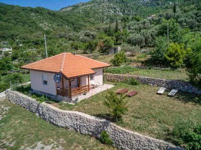 a small house on a hill with a stone wall at Two Bedroom House with Sea View MAJ in Ðurovići