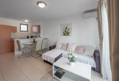 a living room with a couch and a table at Sea view Two bedroom Family Apartment with pool - Sunset Ivanovići in Becici