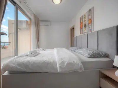 a white bedroom with a large bed with a window at Sea view Two bedroom Family Apartment with pool - Sunset Ivanovići in Becici