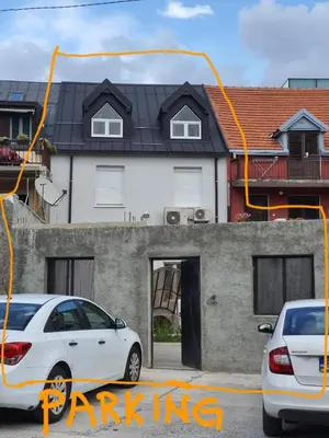two cars parked in front of a house at Downtown apartment in Cetinje