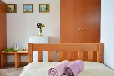a bedroom with a bed with two purple towels at NEXT DOOR HOUSE in Ulcinj