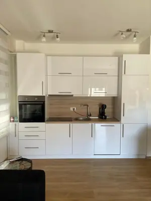 a kitchen with white cabinets and a sink at Anja Lux Apartman in Budva