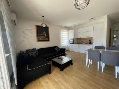 a living room with a couch and a table and a kitchen at Anja Lux Apartman in Budva