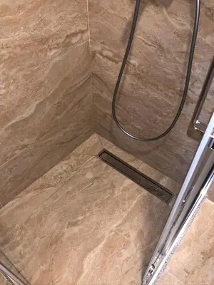 a shower with a hose on a tile floor at Anja Lux Apartman in Budva