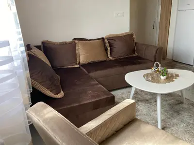 a living room with a brown couch and a table at AparDibra in Bar