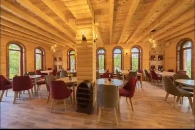 a dining room with tables and chairs and windows at AparDibra in Bar