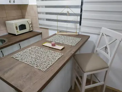 a kitchen with a counter with a microwave and a chair at Sea View Studio in Becici