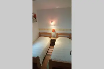 a bedroom with two beds and a table with a lamp at Garden Apartment- near sea 2 in Dobrota