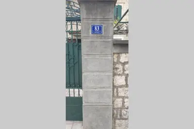 a blue sign on the side of a building at Garden Apartment- near sea 2 in Dobrota