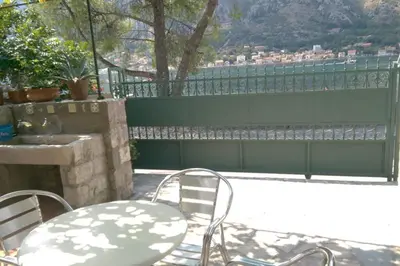 a patio with a table and chairs and a fence at Garden Apartment- near sea 2 in Dobrota
