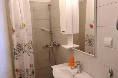 a bathroom with a sink and a shower with a mirror at Garden Apartment- near sea 2 in Dobrota