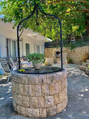 a stone fountain in front of a house at Oldmill Apartment in Ulcinj