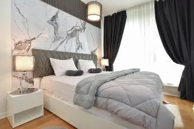 a bedroom with a large bed with a marble wall at Apartment in the luxury hotel near beach in Budva