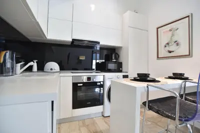a kitchen with white cabinets and a stove top oven at Apartment in the luxury hotel near beach in Budva