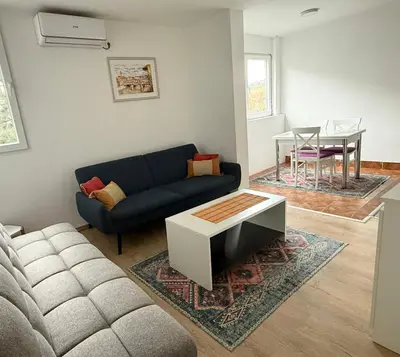 a living room with a blue couch and a table at Podgorica Great location in Podgorica