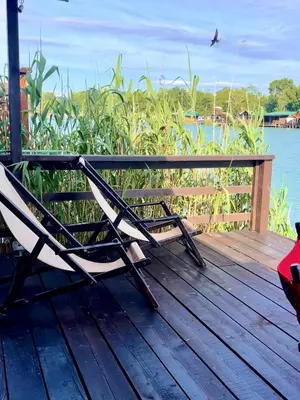a chair sitting on a deck next to the water at Kućica Vjera Ada Bojana in Ulcinj