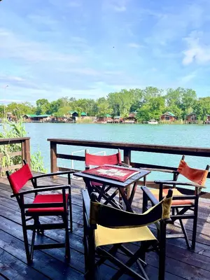 a table and chairs sitting on a deck next to the water at Kućica Vjera Ada Bojana in Ulcinj
