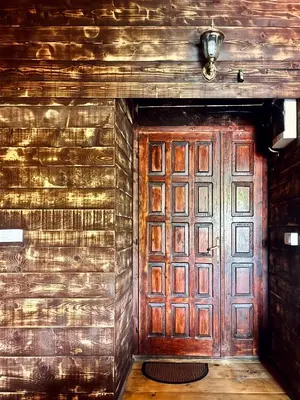 a wooden door in a room with a wall at Kućica Vjera Ada Bojana in Ulcinj