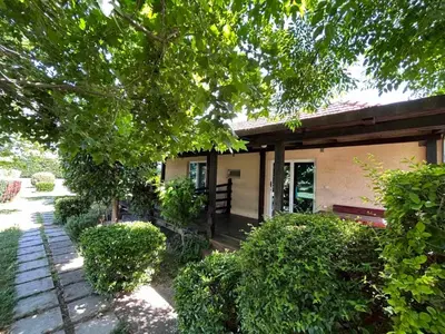 a small house with a porch and bushes in front of it at Christopher's apartments in Ulcinj